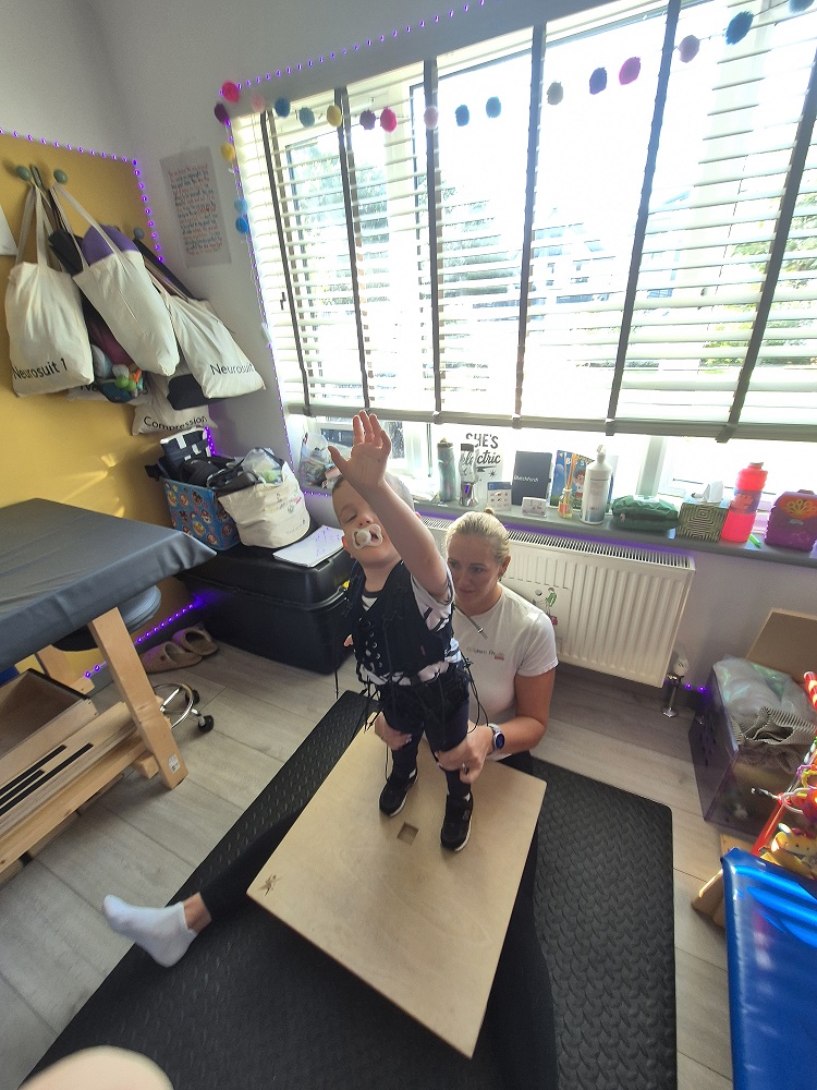 Child taking part in DMI therapy while wearing a NeuroSuit at Children's Physio Dorset